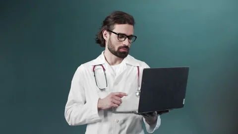 A young black bearded doctor is taking a video consultation on the Internet with Stock Footage 170914330