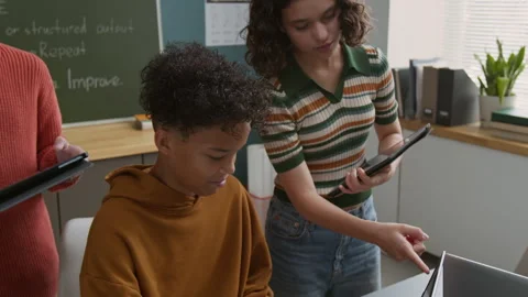 Young Black Boy Writing Code on Laptop and Caucasian Girl Helping Video stock 318715906