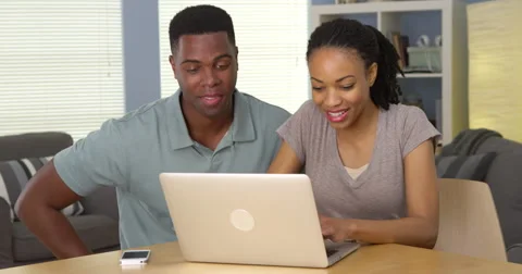 Young black couple browsing internet on laptop together Видео 42658280