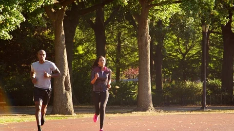 Young black couple jogging in Brooklyn park Stock Footage