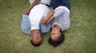 Young Black Couple Lying On Grass Together, Shot From Above Stock Footage