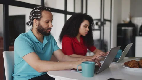 Young Black couple typing on laptops while working remotely from home Stock Footage 332803499