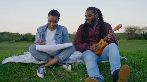 Young black creative couple sitting out in the countryside together, in slow mot Stock Footage 108732314
