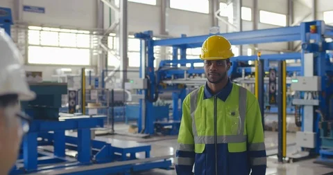 Young black factory worker in uliform and helmet start discussion with his boss Stock Footage 121101466