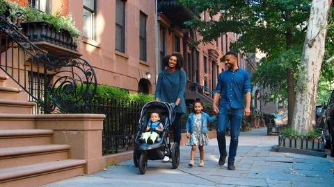 Young black family with stroller walking in Brooklyn street Stock Footage