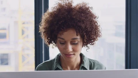 Young black female creative looking at computer monitor in an office and Stock Footage