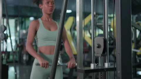 Young black female doing exercises fitness training chest muscles on machine  Video stock 213989264