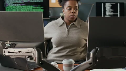 Young Black Female Software Engineer Taking Seat at Office Desk Stock Footage 306840601