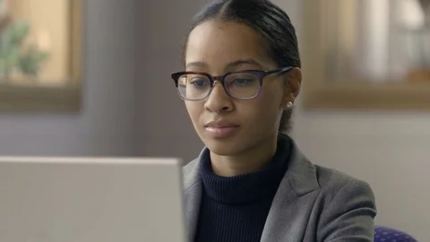 Young black female working at computer in a modern setting, close up Stock Footage 77326186