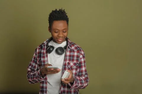 Young black guy connects bluetooth speaker to phone Stock Photos