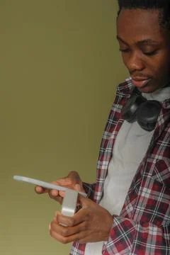 Young black guy connects bluetooth speaker to phone Stock Photos