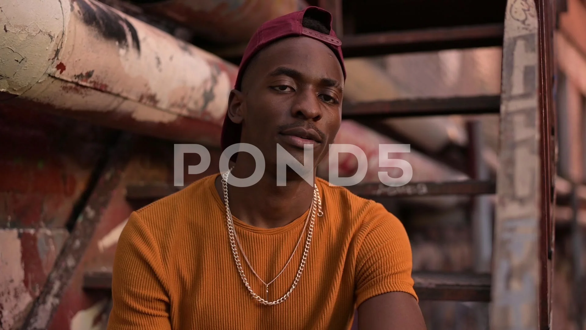 Young black guy in the ghetto. A young man sits on a staircase