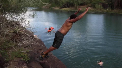 Young black guy jumping into river Vídeos de archivo 60913493