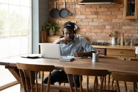 Young black guy learning from home using laptop and headset Stock Photos