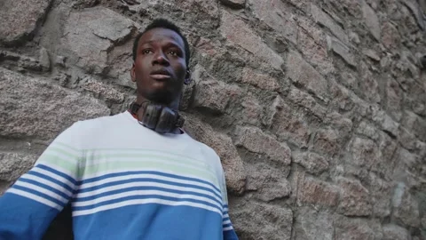 A young black guy poses against the backdrop of a beautiful theater building Stock Footage 155643081