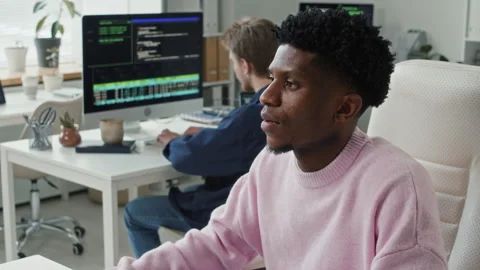 Young Black Male Coder Typing on Computer Keyboard at Desk in IT Office Stock Footage 330126187