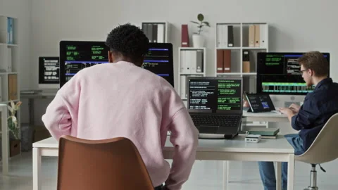 Young Black Male Coder Writing Scripts on Computers at Office Desk Stock Footage 330133256
