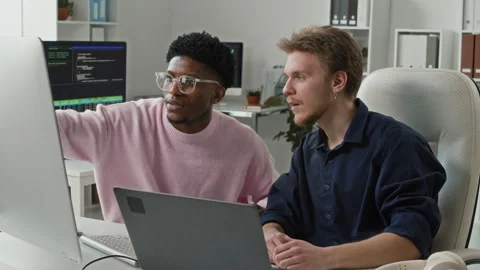 Young Black Male Developer Consulting Peer on Code Error in Office Vídeos de archivo 330125439