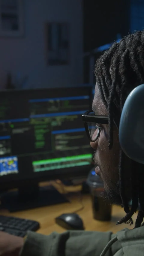 Young Black Male Hacker Coding on Computer in Home Office at Night Stock Footage 328251219