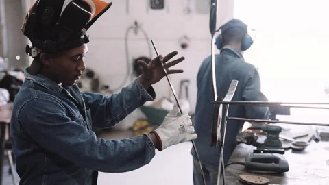 Young black male working testing steel structure in workshop with glove Stock Footage 245498966