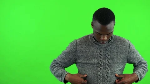 A young black man adjusts his clothes and smiles at the camera - green screen Stock-Footage 78560085