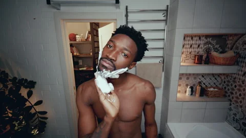 Young Black Man Applying Shaving Cream to Face in Bathroom Stock Footage 294848189