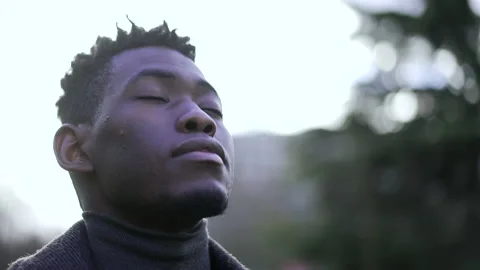 Young black man closing and opening eyes in meditation and contemplation. Afr Stock Footage 150979748