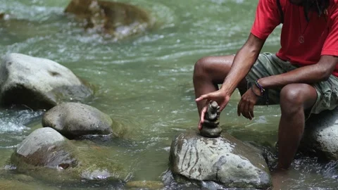 A Young Black Man Destroying a Stack of Small Rocks Stock Footage 207654162