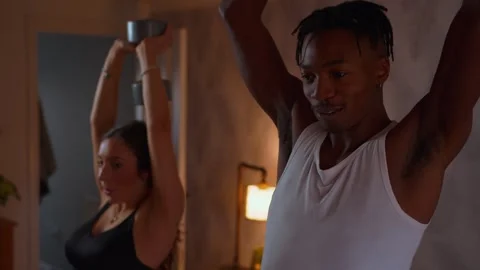 Young Black Man exercising with his girlfriend at home weight training Stock Footage 292245692