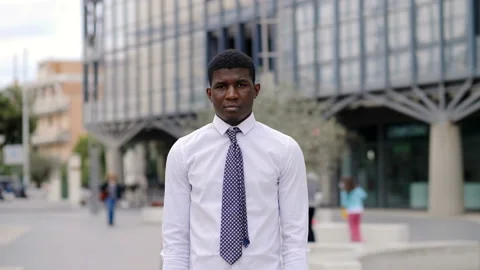 Young black man looking at camera and crossing his arms - outdoors Stock Footage 132517091