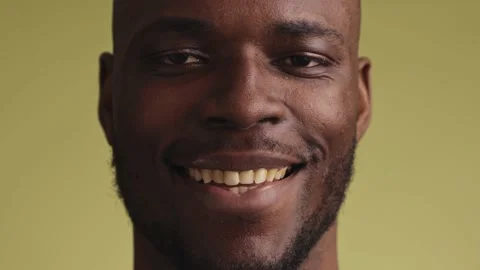 Young black man looks at the camera and smiles 스톡 동영상 233613025
