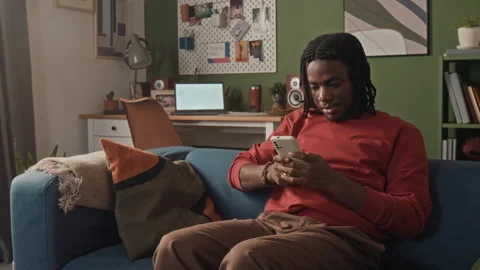 Young Black Man Messaging on Phone in Work Chat while Teleworking from Home Stock-Footage 328246918