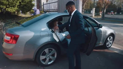 Young black man opens the door of his taxi to a wealthy old woman Stock Footage 154948204