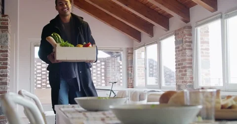Young black man return home from shopping with grocery goods such as vegetables 動画素材 75544244