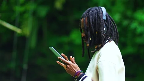 A Young Black Man Seriously Playing With His Tablet at a River Stock Footage 208932031