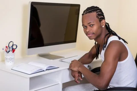 Young black man sitting at computer Stock-Fotos