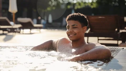Young black man smiling and relaxing in hot tub, hydrotherapy luxury resort Stock Footage 328160080