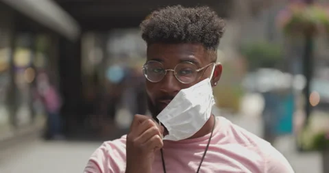 Young black man taking off a mask smiling happy coronavirus covid 5.5k Stock Footage 137858130