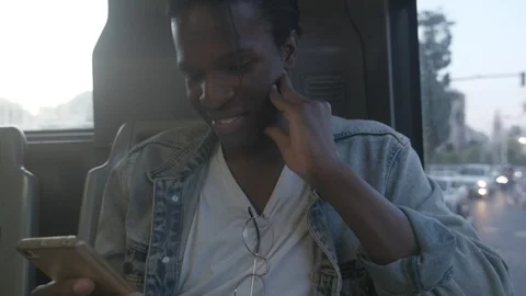 Young black man using his smartphone on a bus Stockbeeldmateriaal 92113014