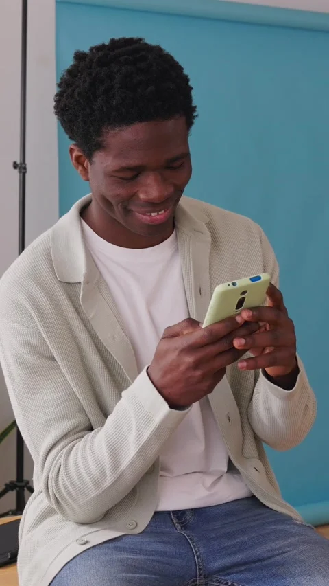Young black man using smartphone in his photo studio Stock Footage 312203046