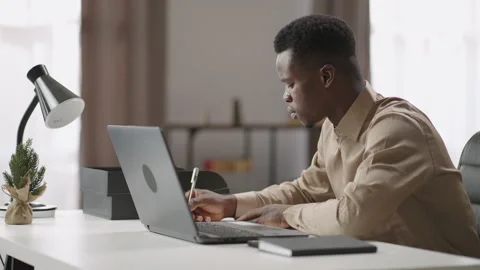 Young black man is viewing and listening online learning webinar on laptop, self Stock Footage 150664196