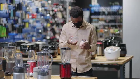 Young black man is viewing mini blender in kitchen appliances department in Stock Footage 153133102