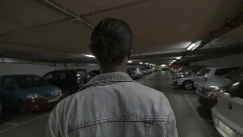 Young black man walking through an underground parking lot, from behind Stock-Footage 92113095
