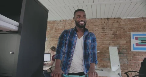 Young black man waves hand and says bye to colleagues Stock Footage 112534554