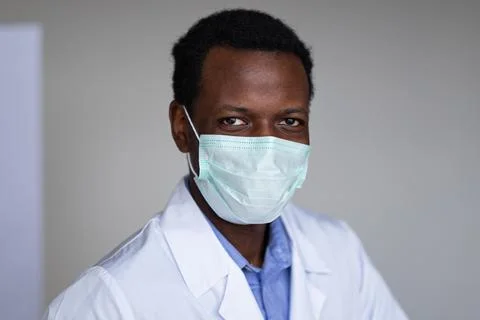 Young black man wearing a white coat and face mask Stock Photos
