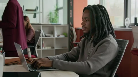Young Black Man Working on Laptop in Modern Open Office Stock Footage 333400668