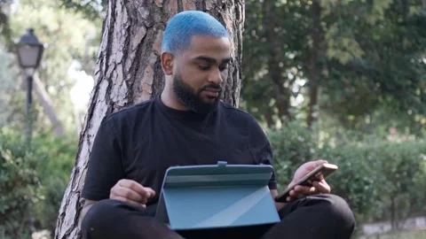 Young black man working remotely in a park with 스톡 동영상 287491675