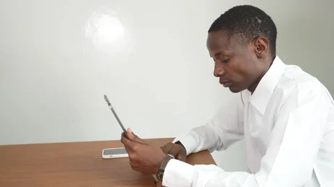Young black man working on a tablet in an office at a table 스톡 동영상 278477191