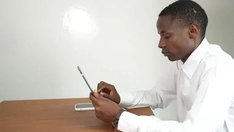 Young black man working on a tablet in an office at a table 스톡 동영상 278477559