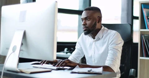 Young black man working use computer in office smiling technology african Stock Footage